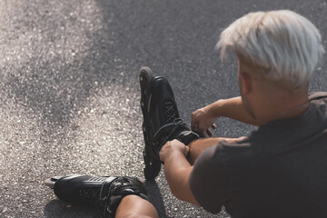 a gay boy riding on in-line skates skating on a road.
