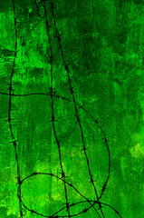 Barbed wire on grungy old wall in green