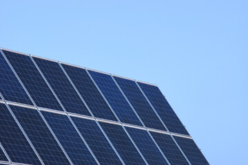 Placas solares en un día despejado con el cielo azul.