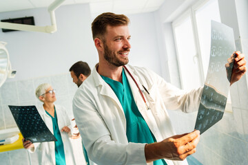 Doctors discussing patient's diagnosis looking at x-rays in a hospital