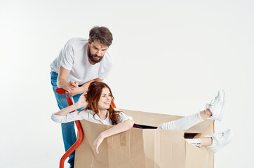 a young couple shipping transport in a box light background