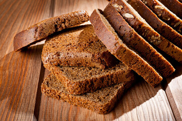 Bread made from natural products, on live sourdough, without baker's yeast, cut into skibbles on a wooden table surface.
