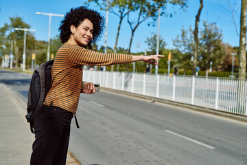 Obraz premium Attractive young woman hailing a taxi by the road
