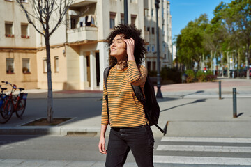 Fototapeta premium Beautiful young woman walking a backpack