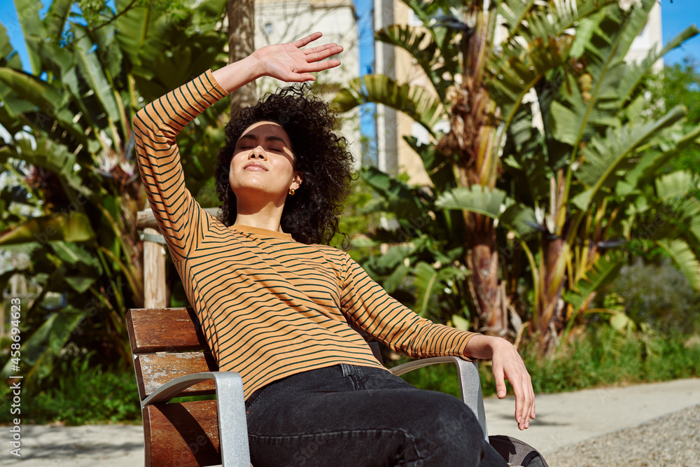 Wall mural Young woman blocking the sun while relaxing