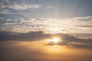 Gentle sunset in the clouds. The rays of the sun are visible.