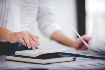 businessman or accountant who are using a calculator to calculate business data Accounting documents and laptop computer at the office business idea