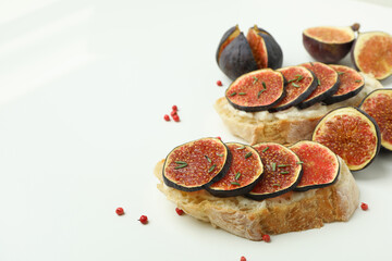 Tasty bruschetta with fig on white background