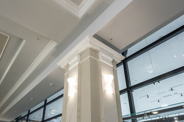 column in interior with suspended and grid ceiling with halogen spots lamps and drywall...