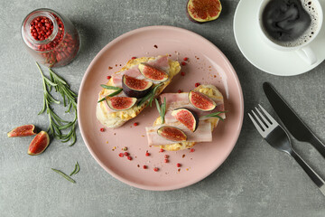 Concept of tasty food with bruschetta with fig on gray textured table