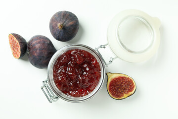 Jar with fig jam and ingredients on white background