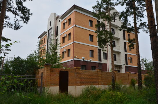 A square orange building with fence