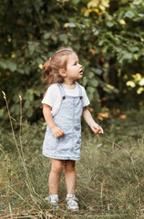 Positive charming little girl enjoying summer sunny day, expression emotions, having fun, happy child walking in summer day