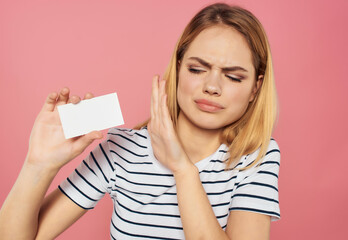 cheerful woman in a striped T-shirt with a business card in hand Copy space