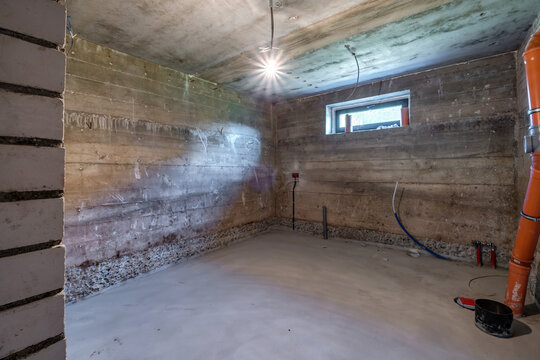 Empty basement room with minimal preparatory repairs in interior with white brick walls