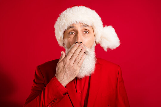 Portrait of attractive worried suspicious bearded grey-haired man closing mouth dont speak isolated over bright red color background
