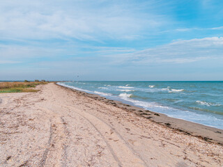 The athlete practices kite board surfing on blue sea waves. Autumn kiteboarding. Fall ocean fun....