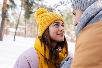 Smiling woman looking at boyfriend in winter park