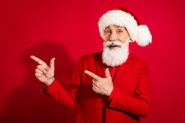 Photo of old happy man point finger empty space good mood xmas celebrate isolated on red color background