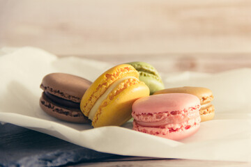 French macarons cookies in pastel colors on slate tray and paper. Copy space. Selective focus.