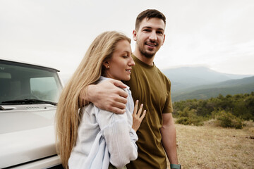 Young couple is on romantic trip to the mountains by car