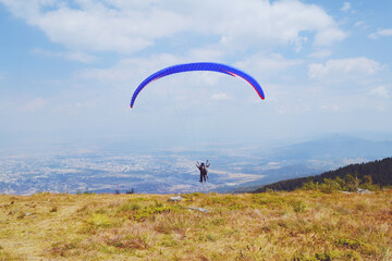 Paraglider Flying  in the Blue Cloudy Sky