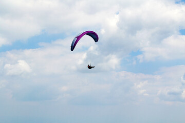 Paraglider Flying  in the Blue Cloudy Sky