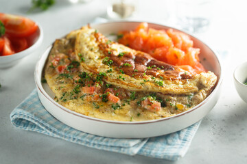 Traditional homemade omelette with tomatoes and salmon