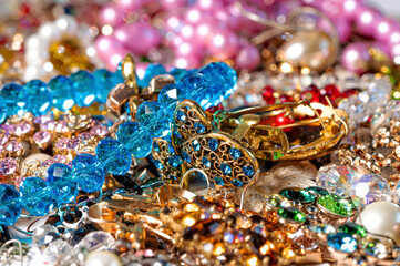 necklaces, earrings, bracelets, pearls, beads and various colored gemstones as a background