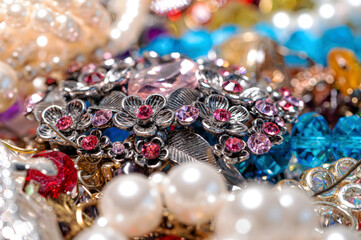 necklaces, earrings, bracelets, pearls, beads and various colored gemstones as a background