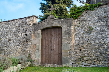 puerta de madera en iglesia de tavertet con muro de piedra con cielo azul, cataluña españa