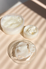 Natural eco handmade facial balm in white jar, striped shadow background.