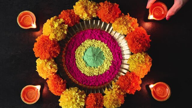 Woman decorating Diya oil lamp Diwali celebration Indian festival of lights and colors Rangoli flowers flowerbed 4K footage video greetings Dipavali Hindu festival North India, Mumbai Delhi India
