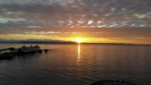 Aerial shot of ocean sunset with ferry in the foreground.