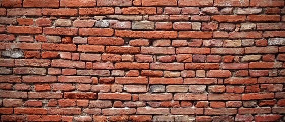 Ancient brick wall of an historical building in Italy with deformation due to centuries, original irregular pattern, textured background.