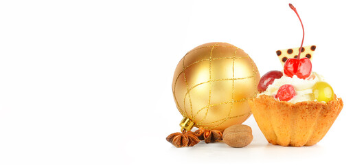 Christmas composition: Christmas ball, cake and aromatic spices isolated on a white. There is free space for text. Wide photo.