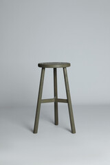 Stylish wooden stool on light grey background. Interior element