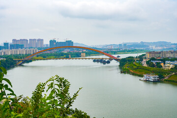 Naklejka premium Small county town buildings and rainbow bridge across the river in Guangxi, China