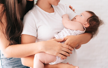 A young happy female couple and their child are enjoying together at home. lesbian couple