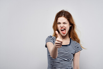 Obraz premium beautiful woman in a striped t-shirt red lips gesture with his hands model studio