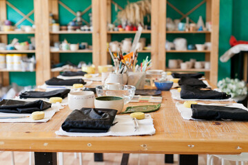 table with tools set for art master class at pottery studio