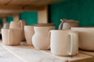 Fototapeta na wymiar ceramic neutral color clay tableware on the shelf 