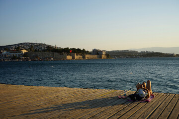 Blick von alten Schiffsdielen an der Uferpromenade am Hafen auf die gegenüberliegende Festung im...