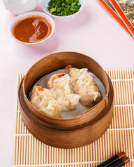 Assorted Chinese Dimsum in bamboo basket. Dimsum is a large range of small dishes that Cantonese people traditionally enjoy in restaurants for breakfast and lunch.