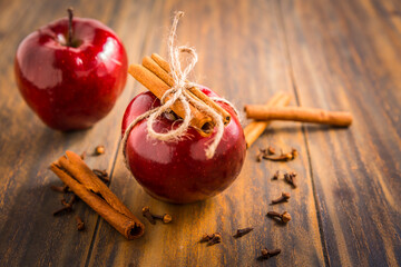 Organic red apples with cinnamon stick and cloves as baking ingredients