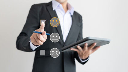 A smart bussinessman is holding tablet and choose to rating score happy icon service experience....