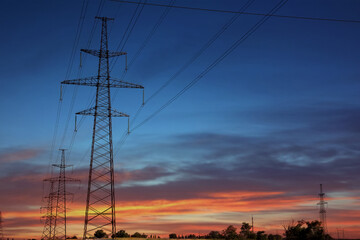 Telephone poles with cables at sunset outdoors