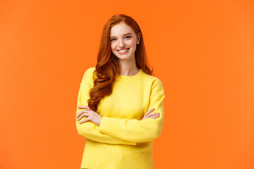 Holidays, people and winter concept. Attractive young smiling girl with red hair in yellow sweater...
