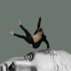 Modern conceptual artwork with ancient statue head and male ballet dancers. Free fall. Contemporary...