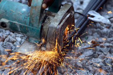 a worker cutting steel bar from cutting machine